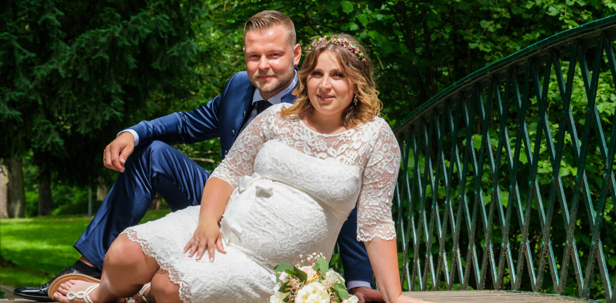 Hochzeitsfotografenmit Brautpaar auf Brücke